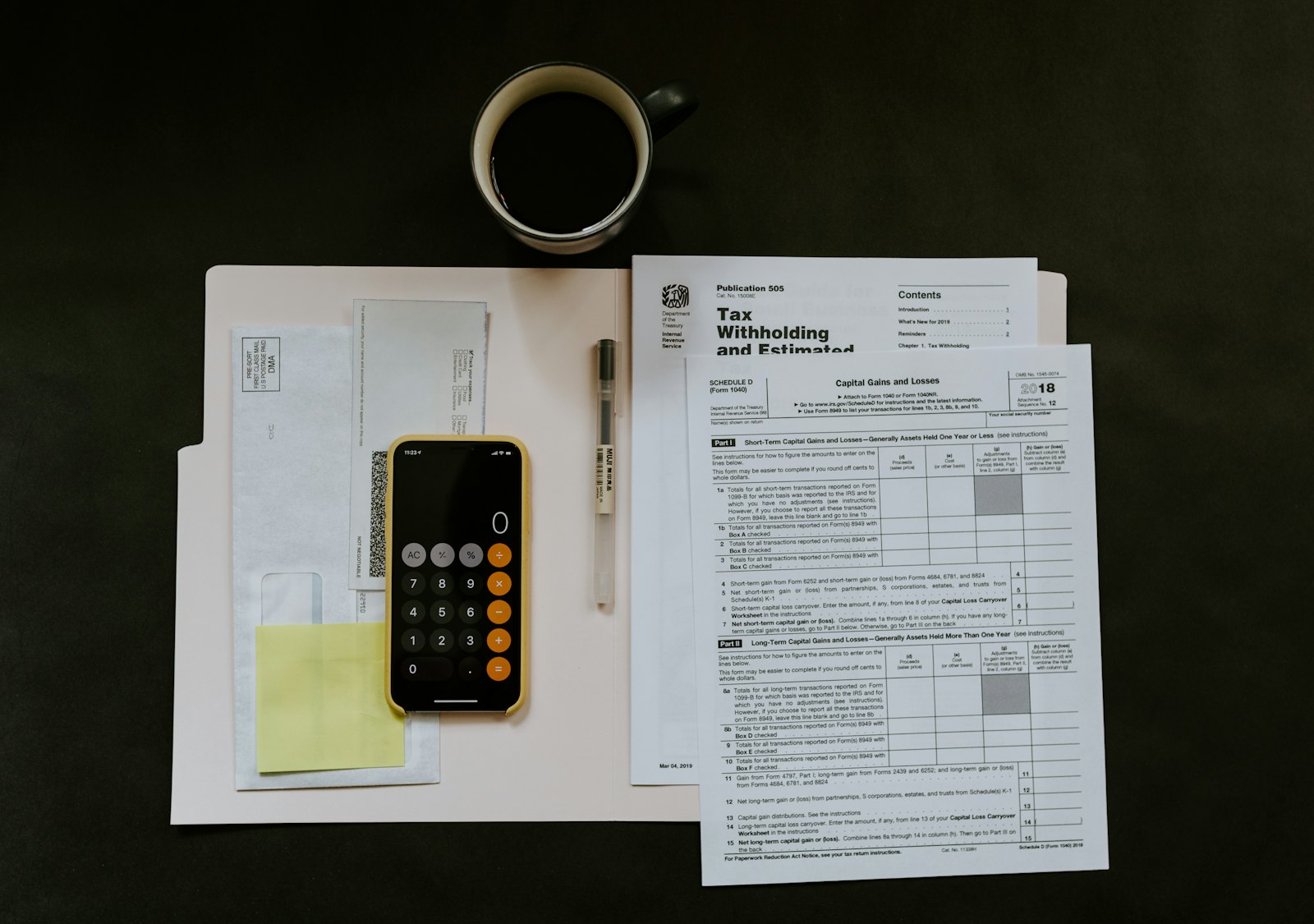 An accountant reconciling monthly figures on a calculator beside a keyboard