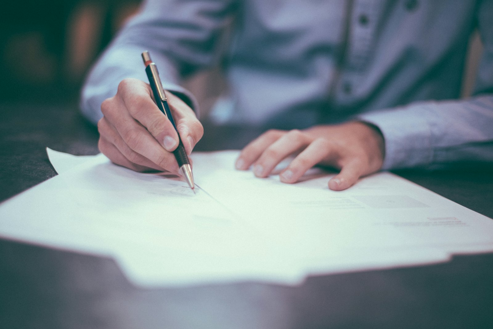 A business owner signing company formation paperwork at a desk